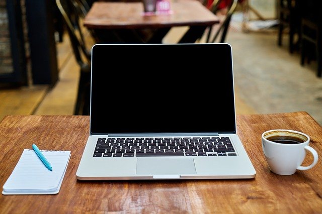 rustikální stolek s notebookem a šálkem kávy